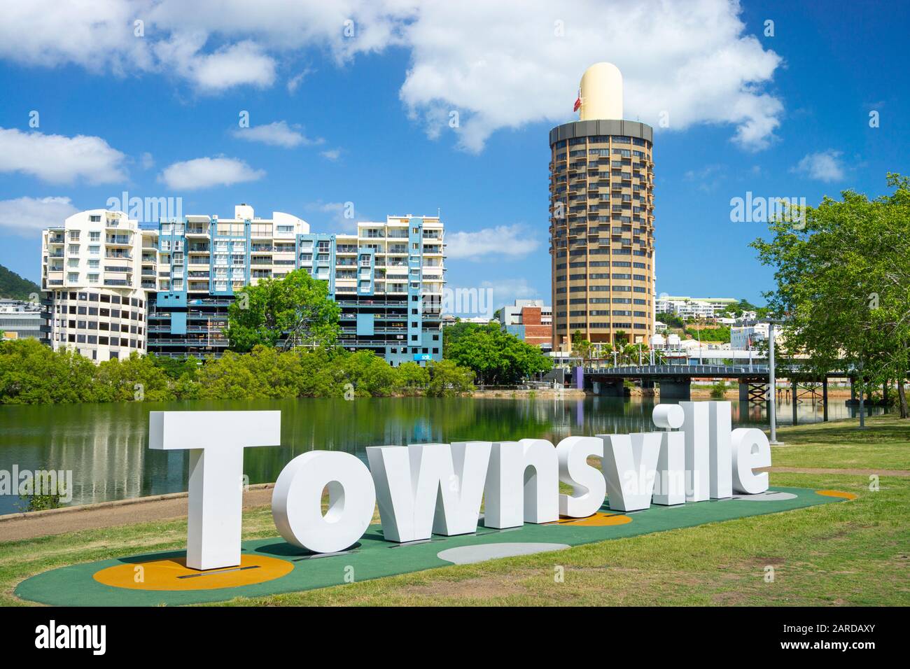 Townsville sign on banks of Ross River with the city skyline and Castle