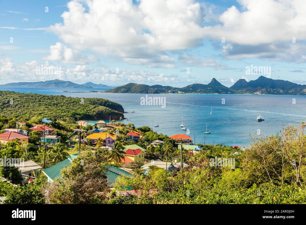 Residential houses at the bay, Mayreau island panorama with Union island in the background, Saint Vincent and the Grenadines Stock Photo