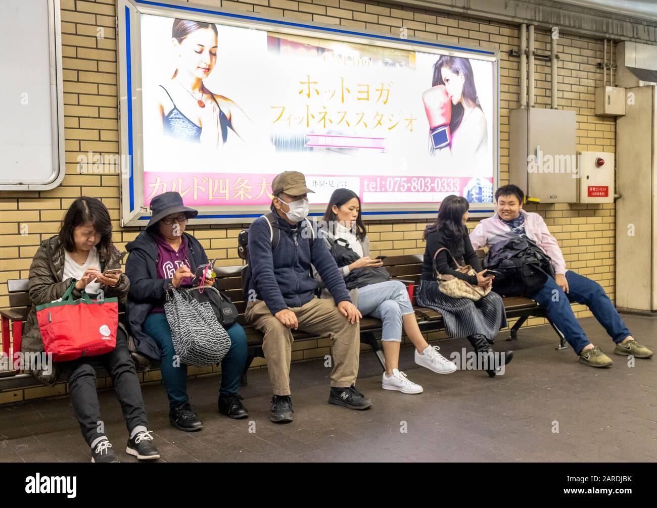 Passengers on platform waiting for metro train, Kyoto, Japan Stock Photo