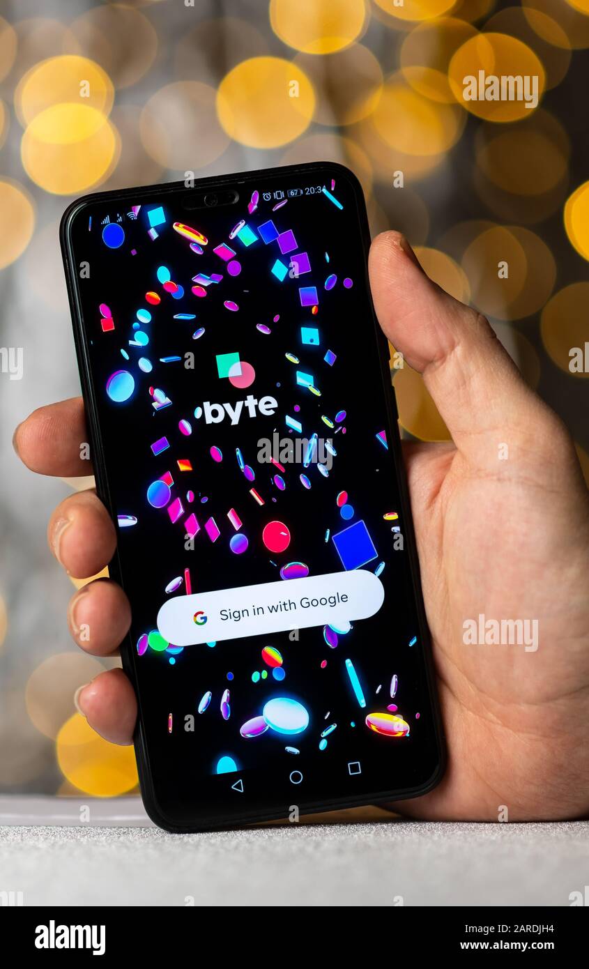Byte app login screen on the smartphone which is hold in hand. Byte app is a looping video social media platform. Stock Photo