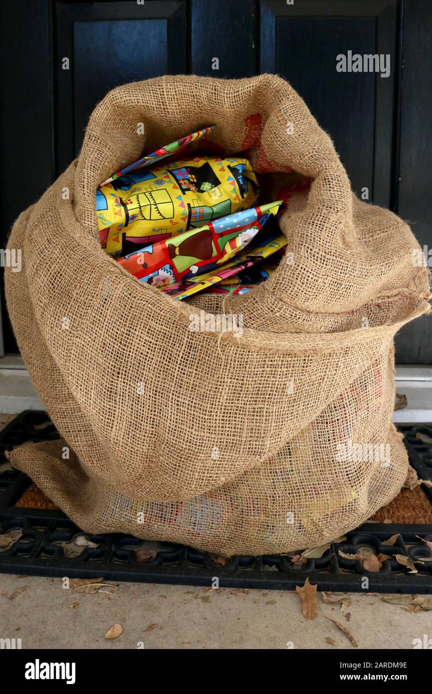 Burlap sack filled with gifts by front door for 'Sinterklaas avond' Stock Photo