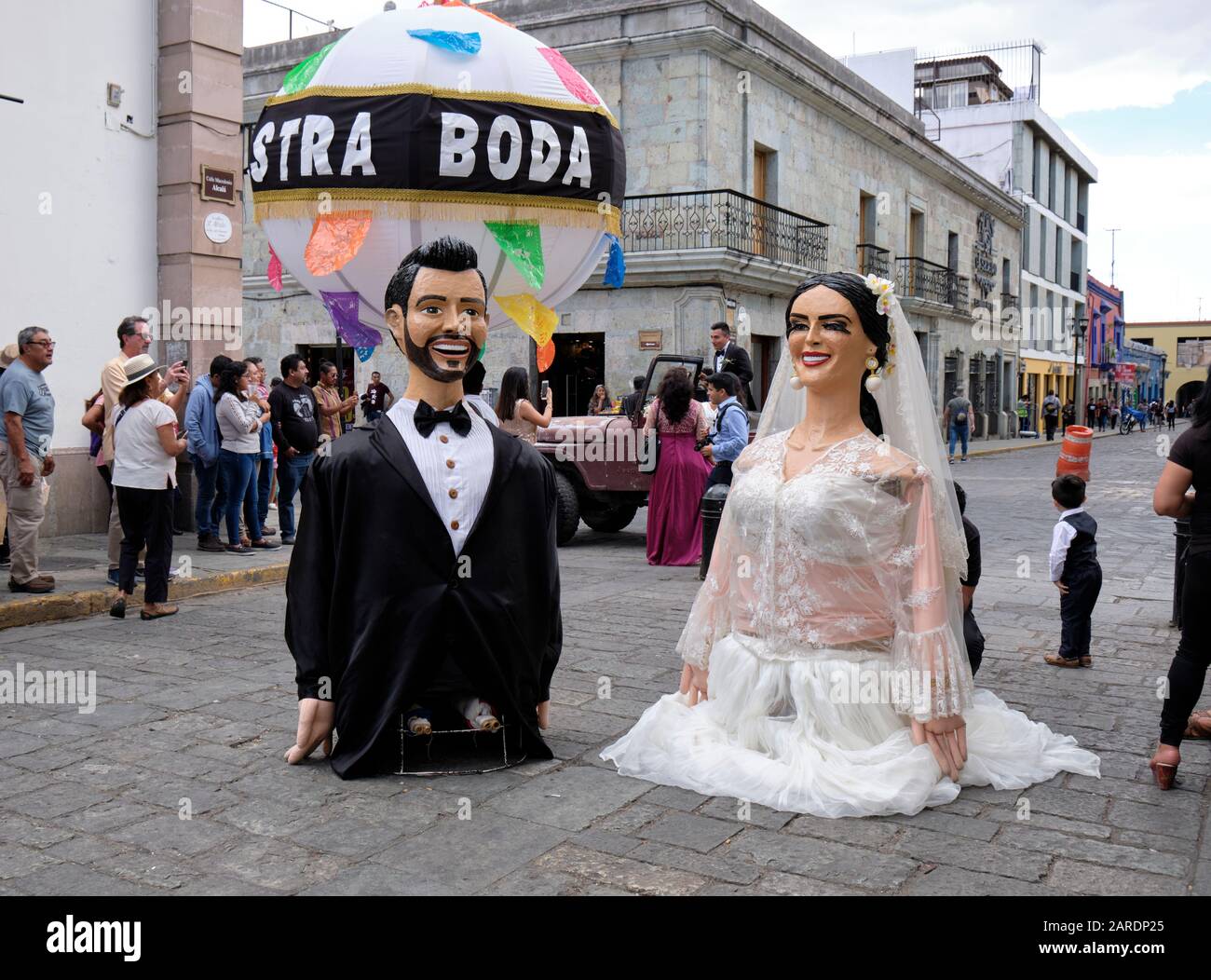 Giant puppet of the Bride and groom with large ball at end of Traditional wedding parade (Calenda de Bodas) on the streets of Oaxaca. Stock Photo