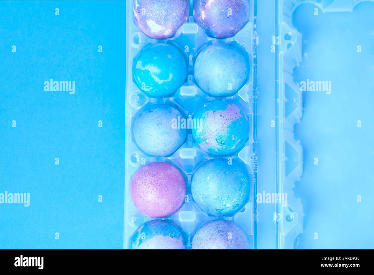 Painted Easter eggs with space intergalactic pattern in stand on blue background Stock Photo