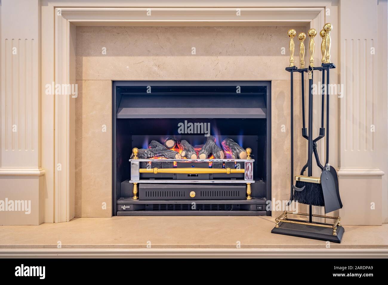 Gas fired classic looking fireplace with tools on the side Stock Photo