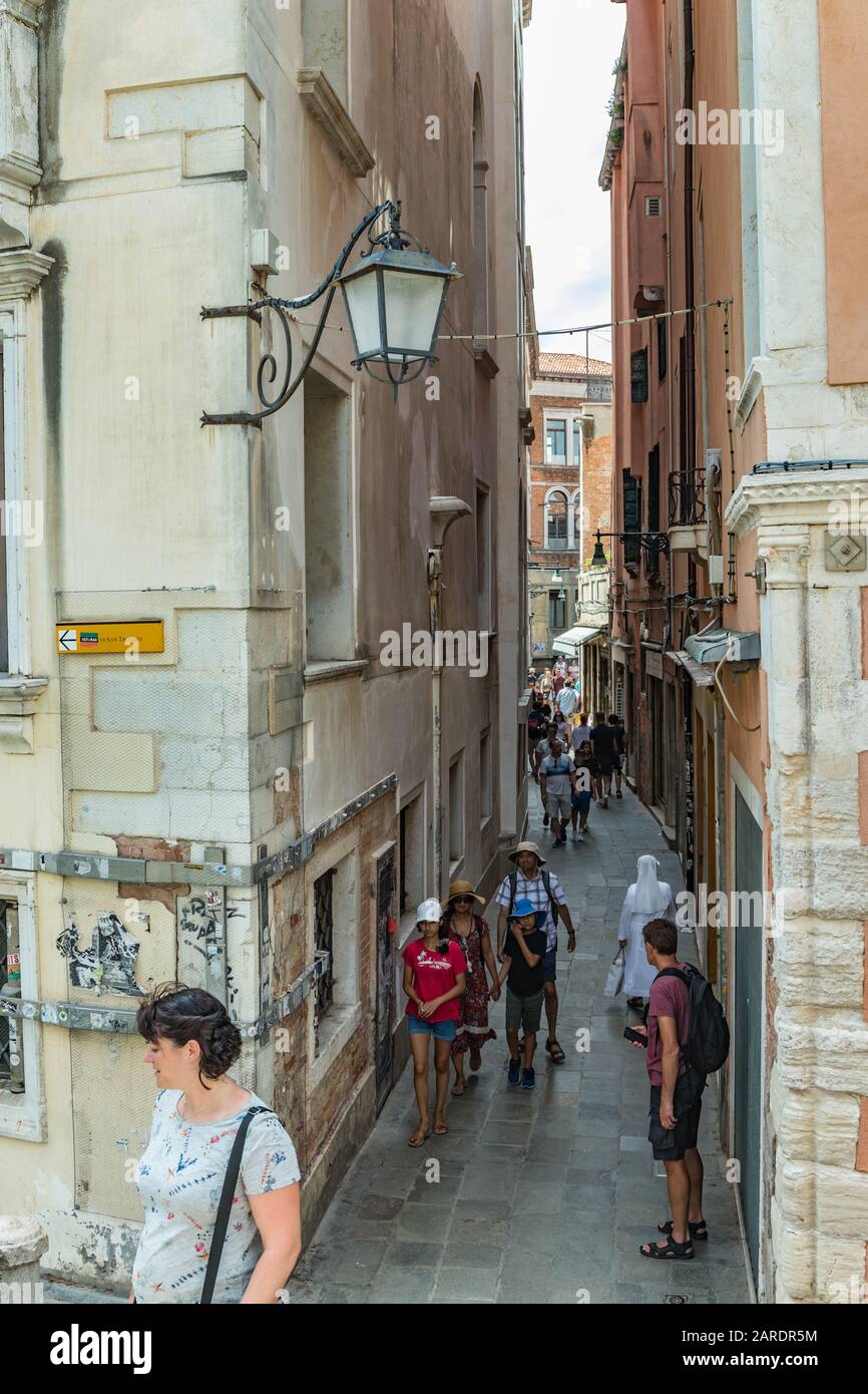 VENICE, ITALY - August 02, 2019: View from bridge in Venice. Locals and tourists strolling along the narrow Venetian pedestrian streets with historica Stock Photo