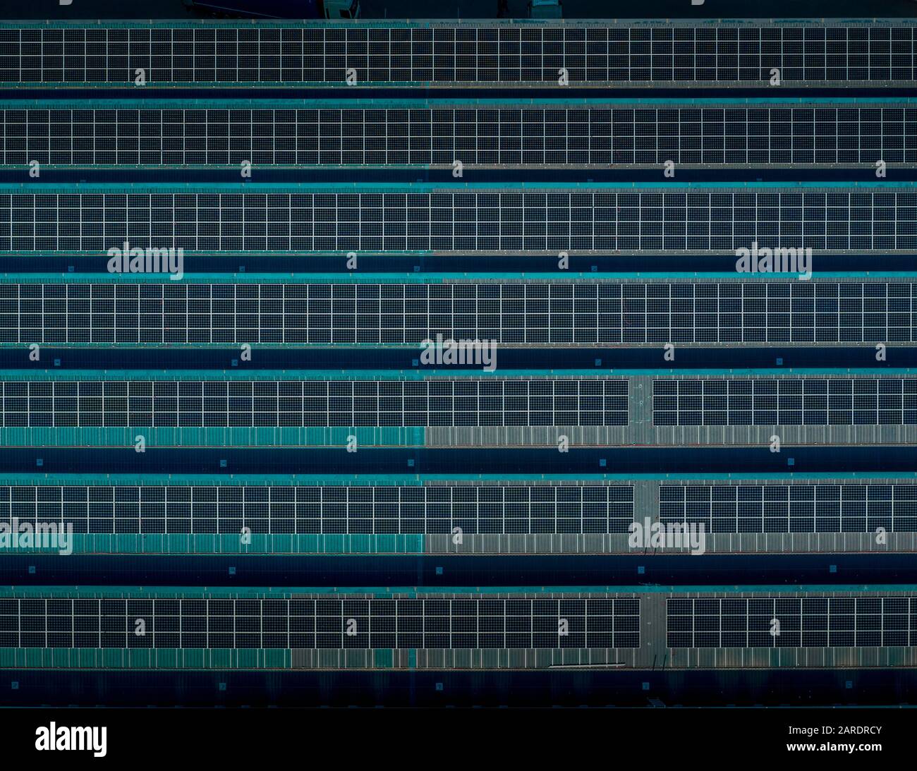 Blue solar panels on the top of a factory building in Spain Stock Photo