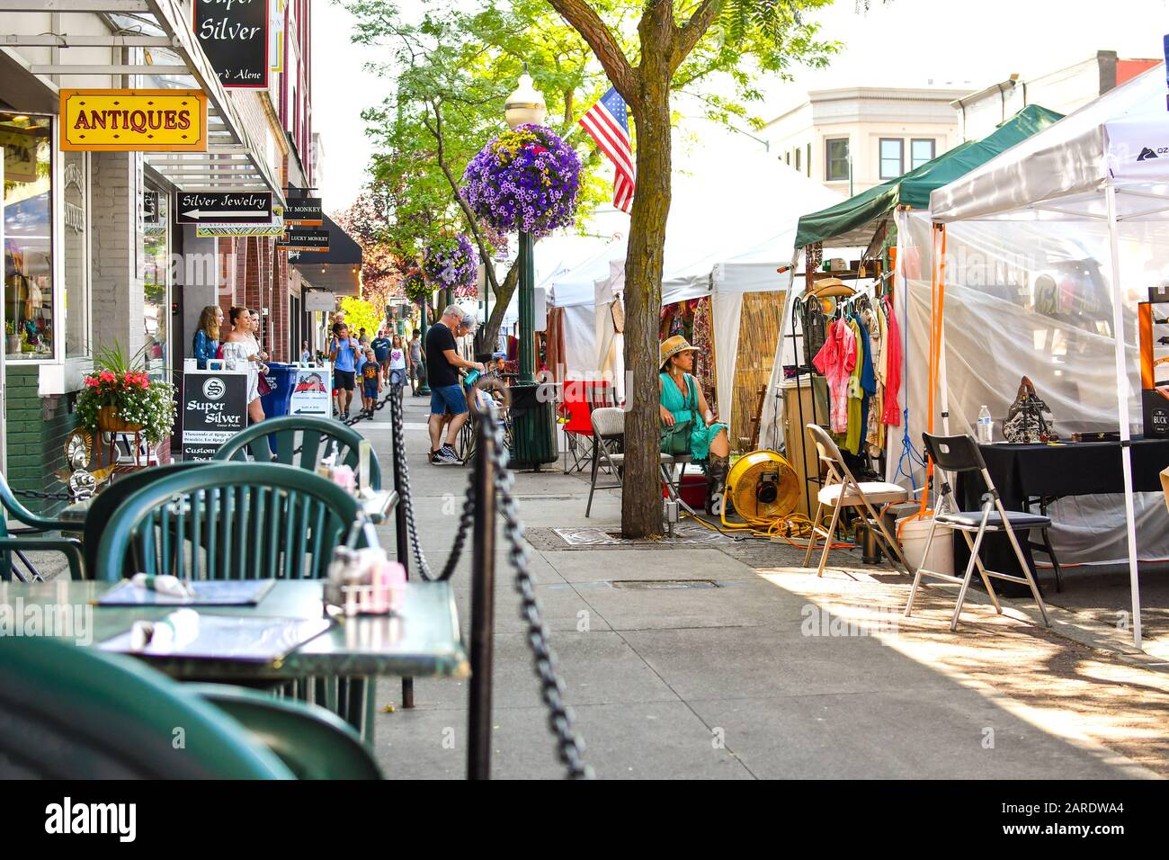 A busy street of shops and cafes during a local flea market fair at Art on the Green festival in the historic downtown of Coeur d'Alene, Idaho. Stock Photo