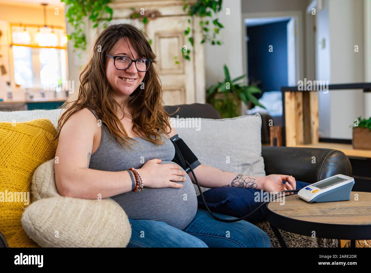 Happy portrait of a young woman in later stages of pregnancy carrying out routine health checks