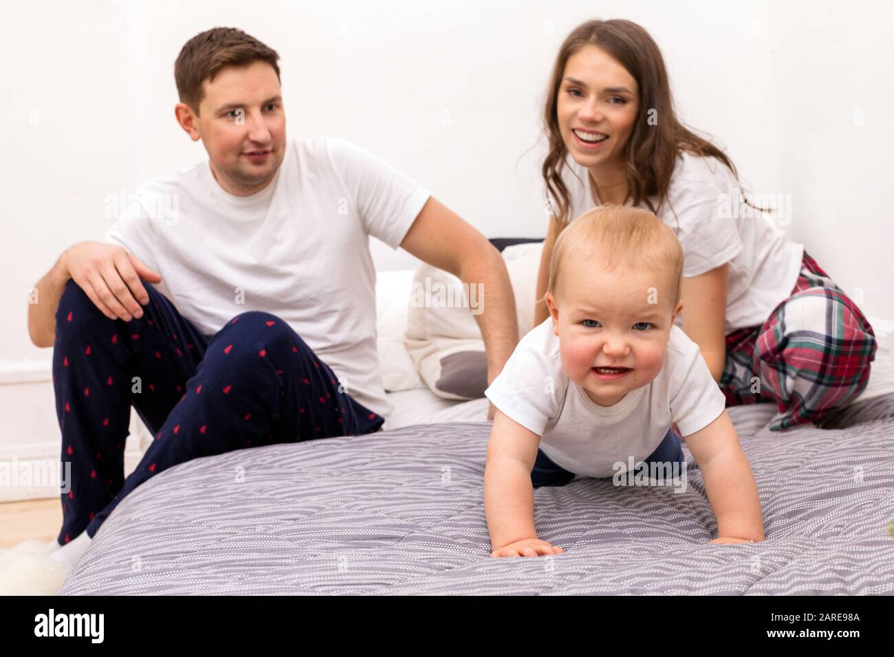 Happy family with funny toddler in bedroom Stock Photo