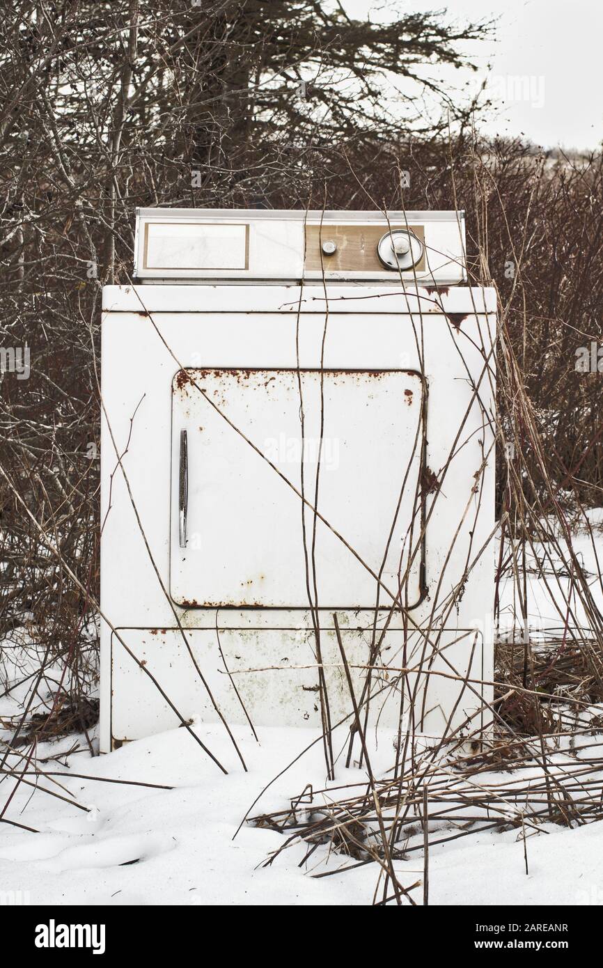 Old and discarded clothes dryer during Winter Stock Photo