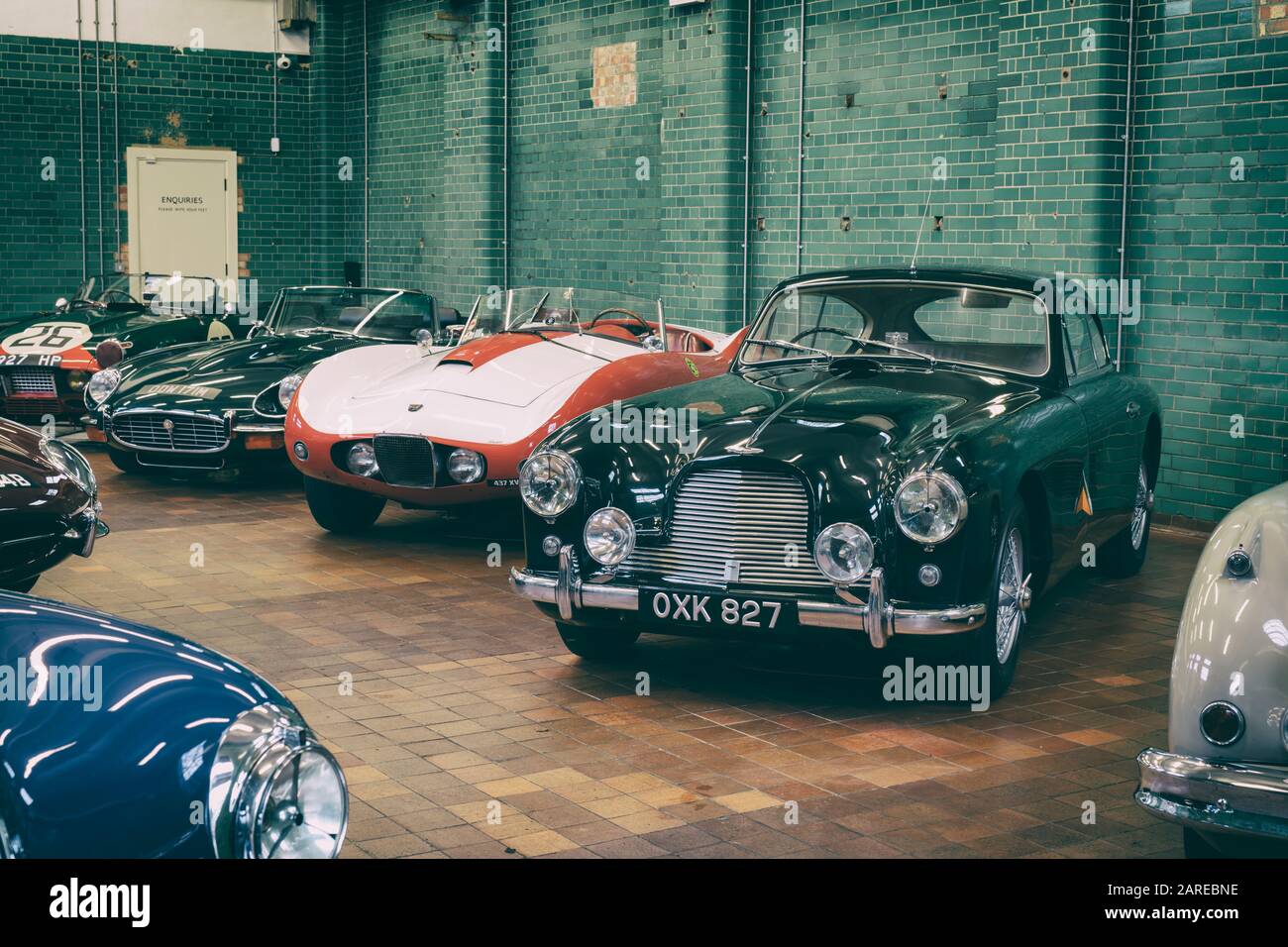 Classic cars inside a workshop at Bicester heritage centre sunday scramble event. Bicester, Oxfordshire, England. Vintage filter applied Stock Photo