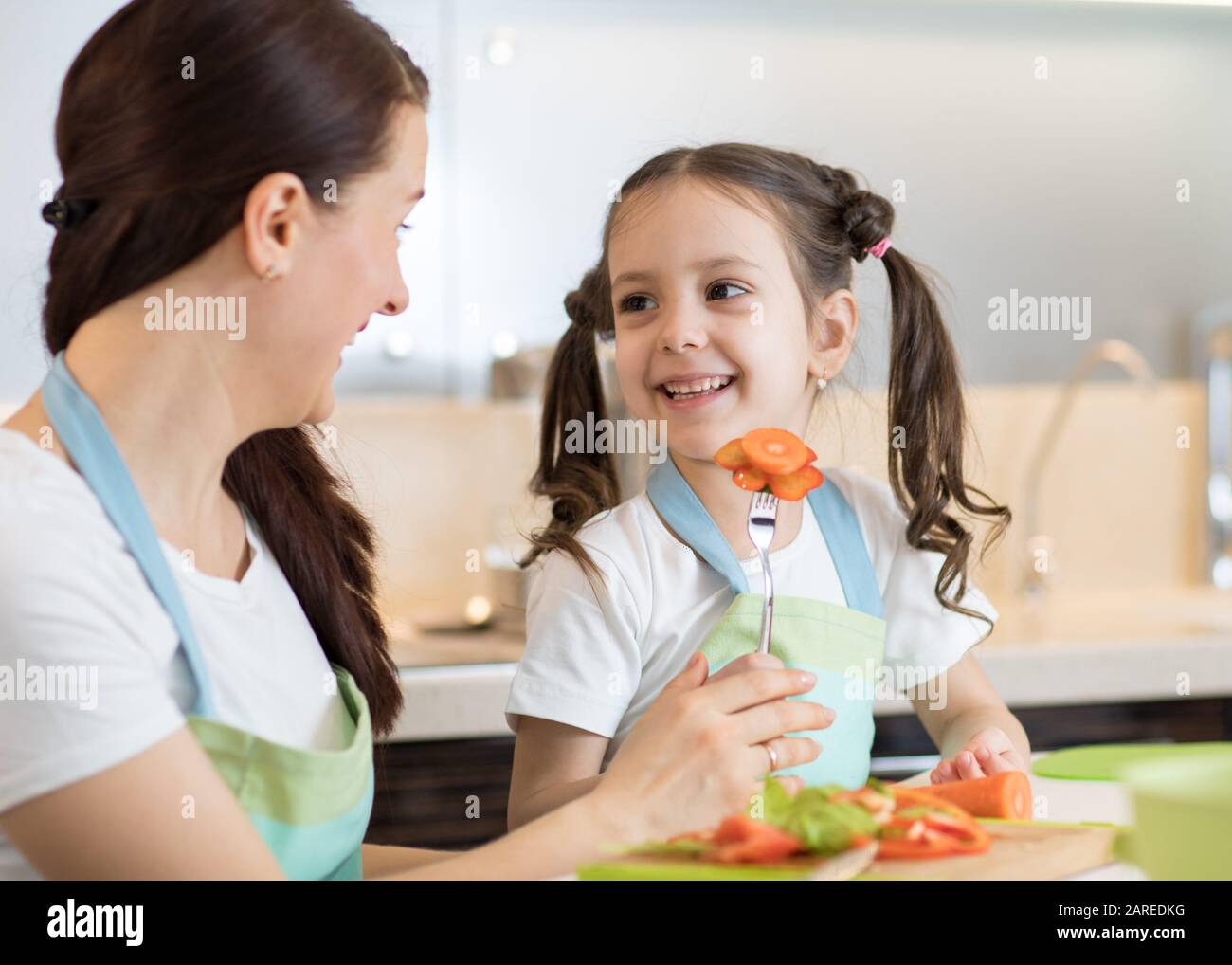 Child cooking with her mother in kitchen Stock Photo