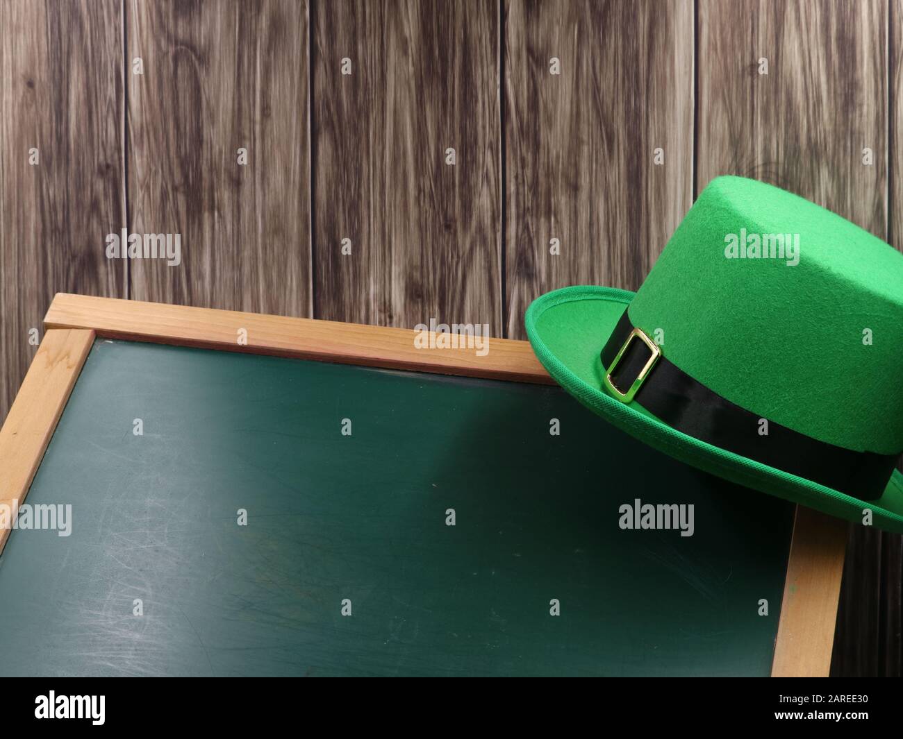 green hat on blackboard and wooden background with copy space, st. patricks day concept Stock Photo