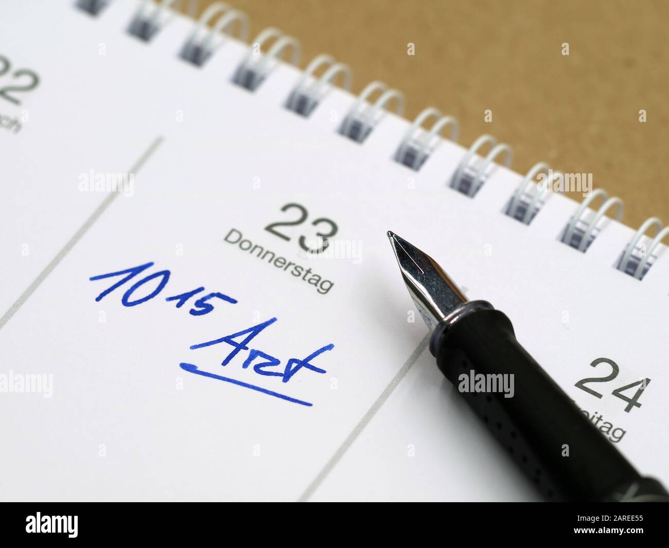 white calendar with german word for doctor's appointment and time written with a fountain pen Stock Photo