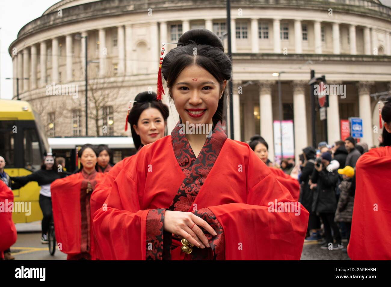 Chinese New Year celebration. Female dancers in traditional Hanfu cross collar  red costume with Manchester Central Library in the bakground Stock Photo