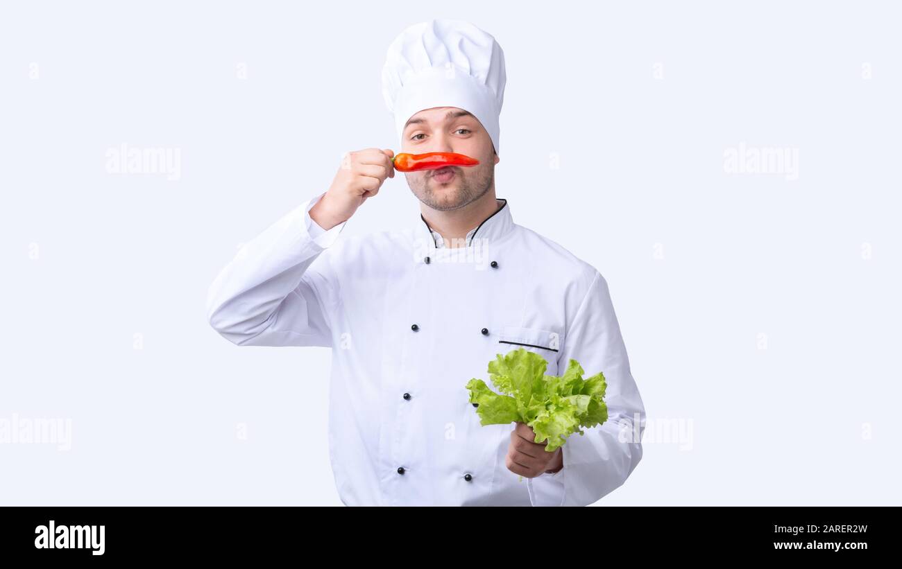 Funny Chef Man Holding Red Pepper Like Moustaches, Studio Shot Stock Photo