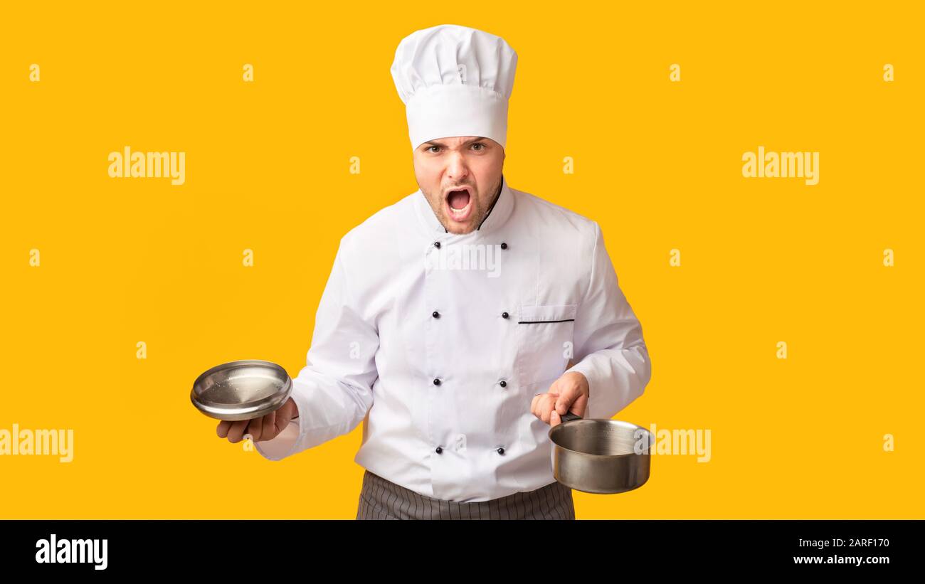 Angry Chef Shouting Holding Saucepan Standing On Yellow Background, Panorama Stock Photo