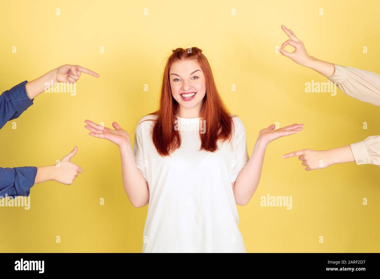 Social ladder. Caucasian young woman's portrait on yellow studio background, too much tasks. Social ladder, psychology, mental health. Concept of office working, business, self management, planning. Stock Photo