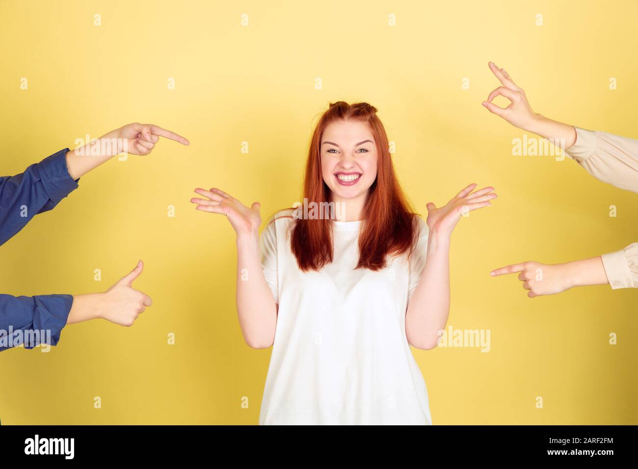 Social ladder. Caucasian young woman's portrait on yellow studio background, too much tasks. Social ladder, psychology, mental health. Concept of office working, business, self management, planning. Stock Photo