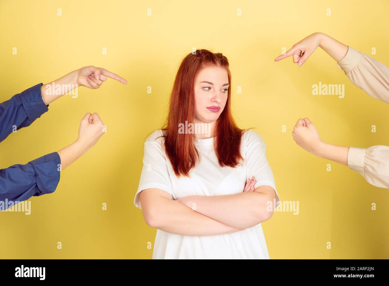 Blaming. Caucasian young woman's portrait on yellow studio background, too much tasks. Social ladder, psychology, mental health. Concept of office working, business, self management, planning. Stock Photo