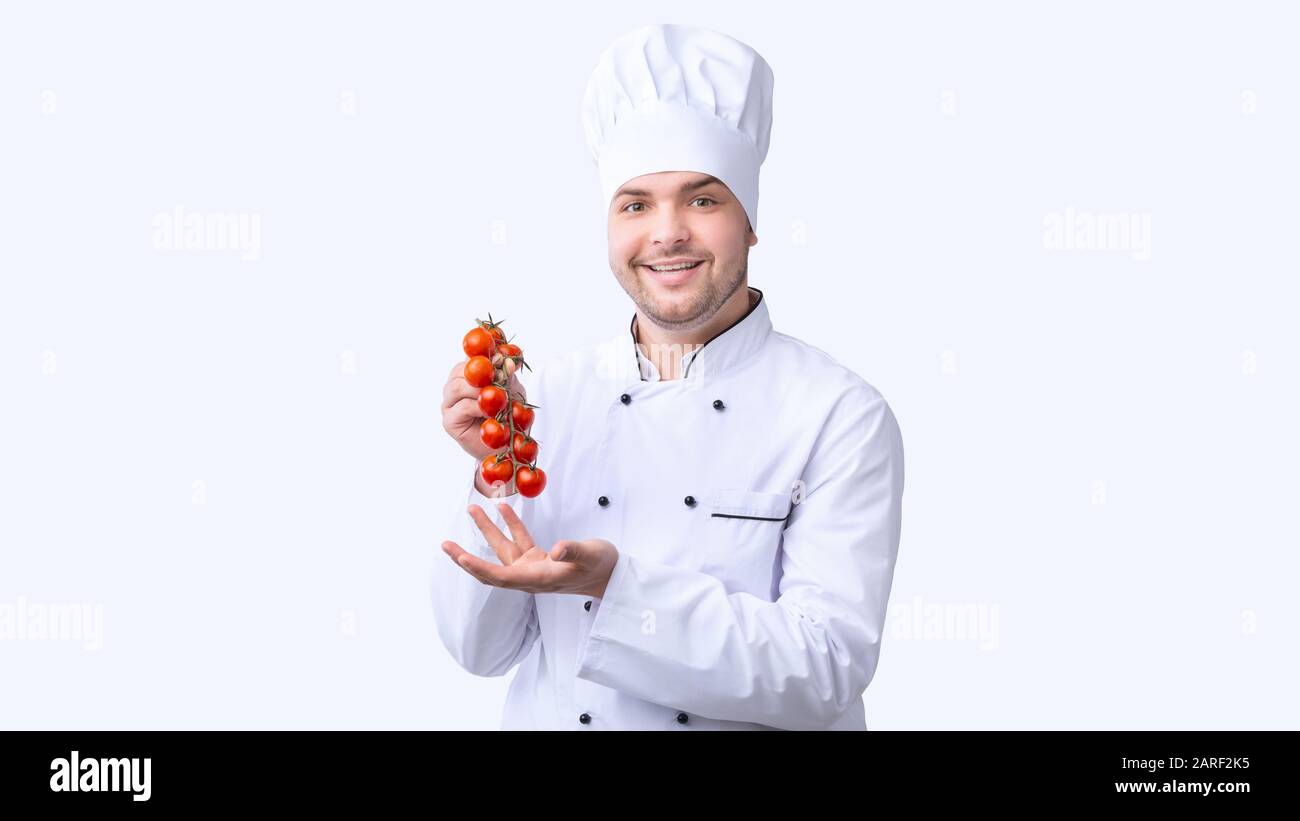 Smiling Chef Man Holding Cherry Tomatoes Branch, White Background, Panorama Stock Photo