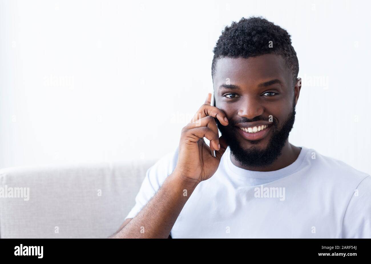 Smiling african american man talking by cellphone Stock Photo