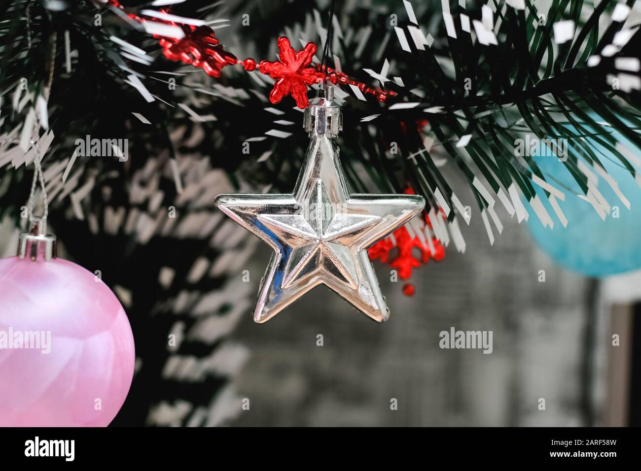 Silver star on a Christmas tree branch Stock Photo - Alamy
