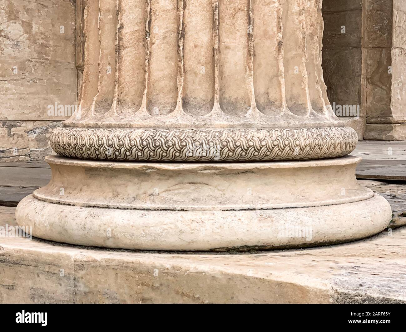Base of a Greek stone column at the Parthenon of Acropolis in Athens, Greece. Detail of a temple pillar with a decorative ornament. Stock Photo