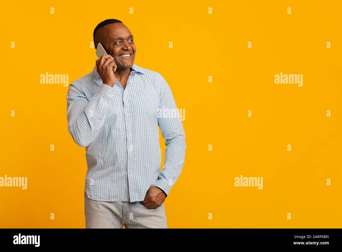 Positive mature afro man talking on cellphone Stock Photo