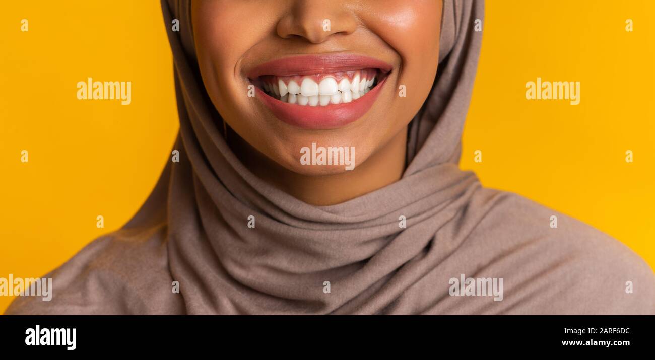 Closeup of perfect white smile of black muslim woman in headscarf Stock Photo