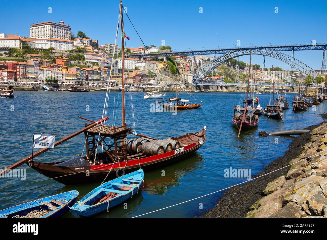 Traditional Portuguese wooden cargo boats transporting port wine, Rio Douro river, Vila Nova de Gaia, Ponte Dom Luis I bridge, Porto, Portugal Stock Photo