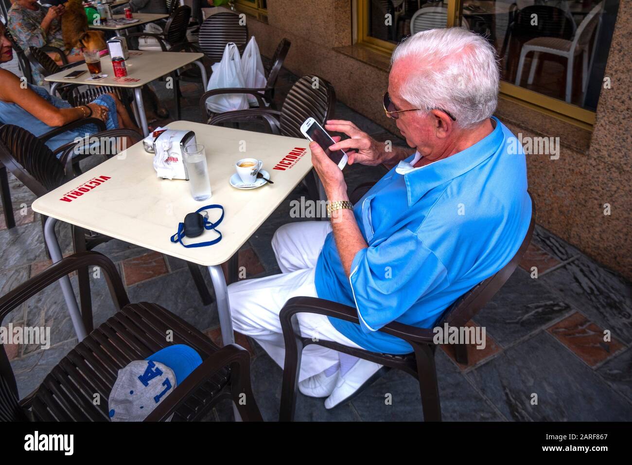 Spain, Andalusia, Malaga, older man using a cell phone, at Fuengirola. Stock Photo