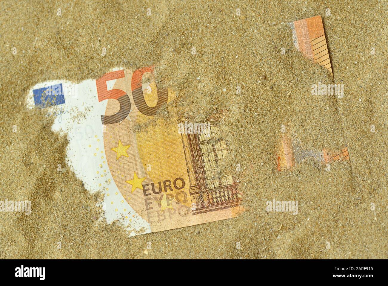 Euro banknote covered by sand - Concept of finance and business Stock Photo