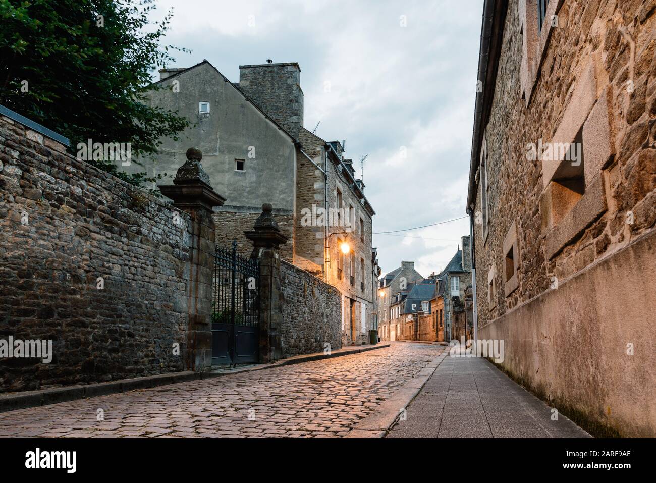 Old cobblestoned street with stone medieval houses in the town centre of Dinan, French Brittany. Stock Photo