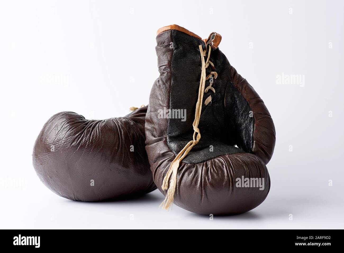 pair of vintage brown leather boxing gloves on a white background