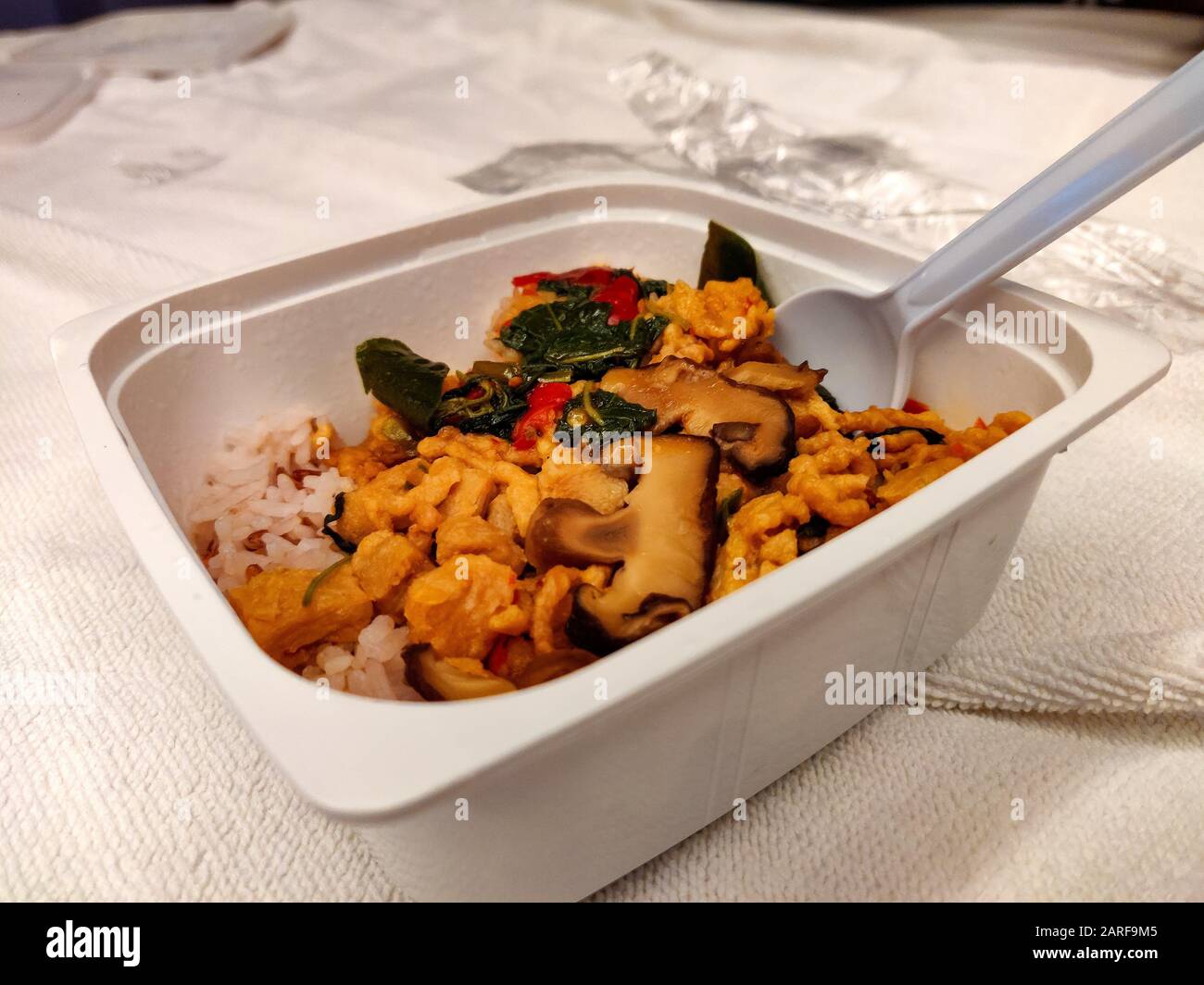 Rice and vegetables served in a plastic box with plastic spoon. Dinner from local store. Ready to eat Pre-Packed frozen food. Stock Photo