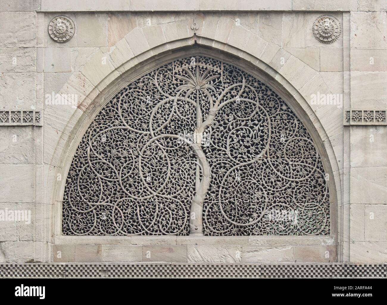 Intricately carved stone latticework windows (jali) with intertwined foilage and palm motif - Sidi Saiyyed Mosque, Ahmedabad, Gujarat, India Stock Photo