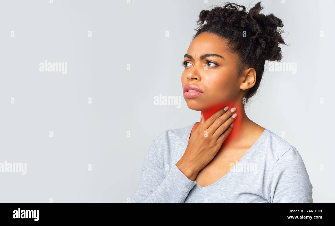 Black woman suffering from sore throat, touching her neck Stock Photo