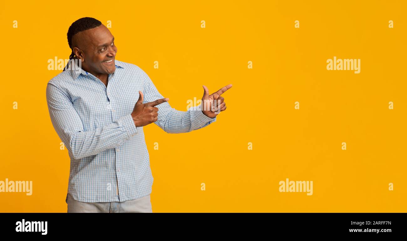 Smiling mature african man pointing aside at copy space Stock Photo