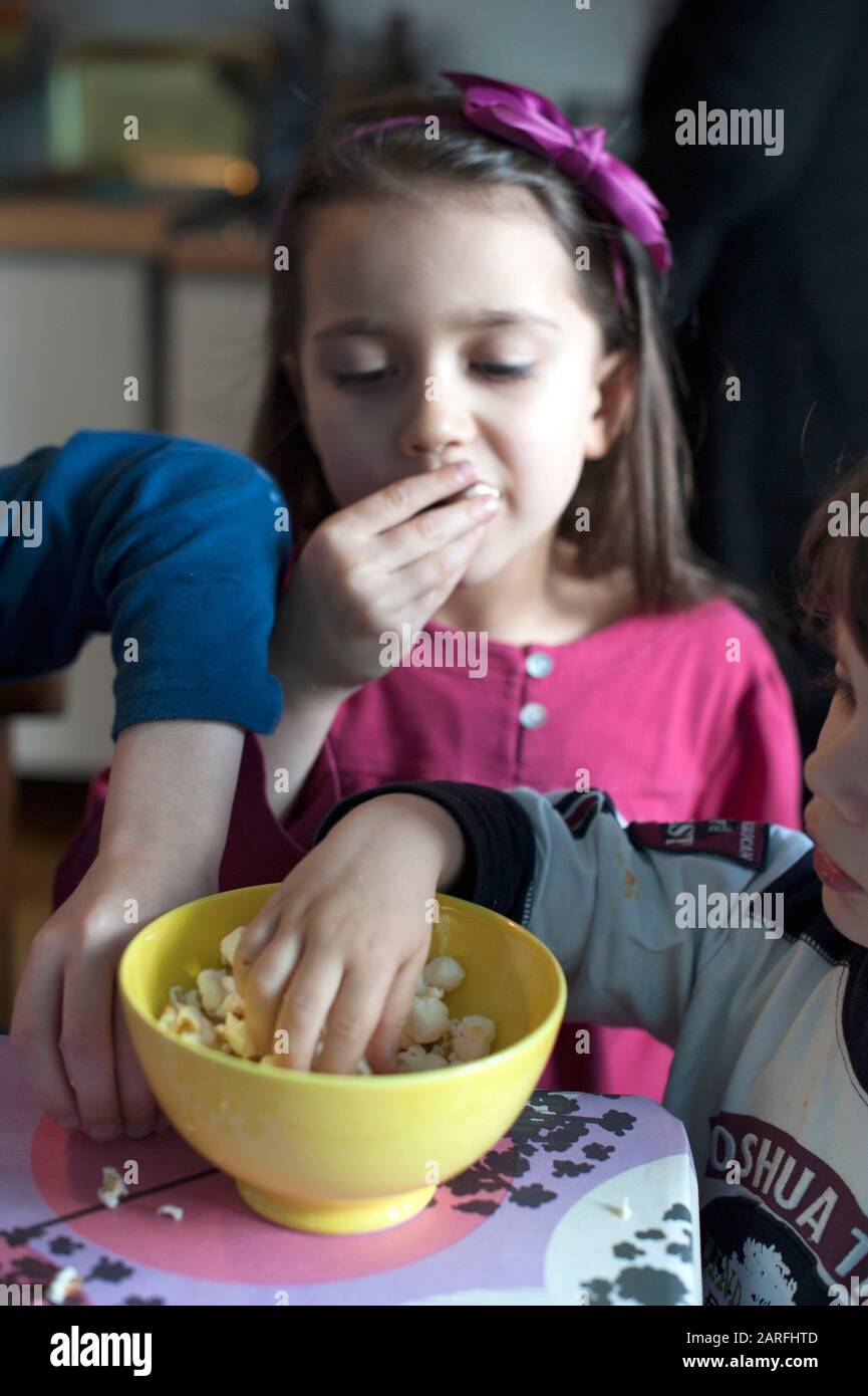 Three children eating popcorn Stock Photo Alamy