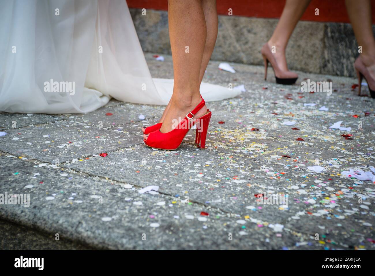 Dress of bride and legs with red shoes with heel Stock Photo - Alamy