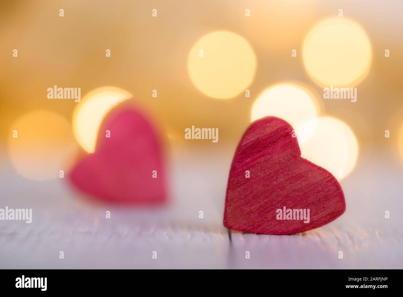 Red wooden hearts against bokeh lights . Copy space and selective focus. Valentines day background. Stock Photo