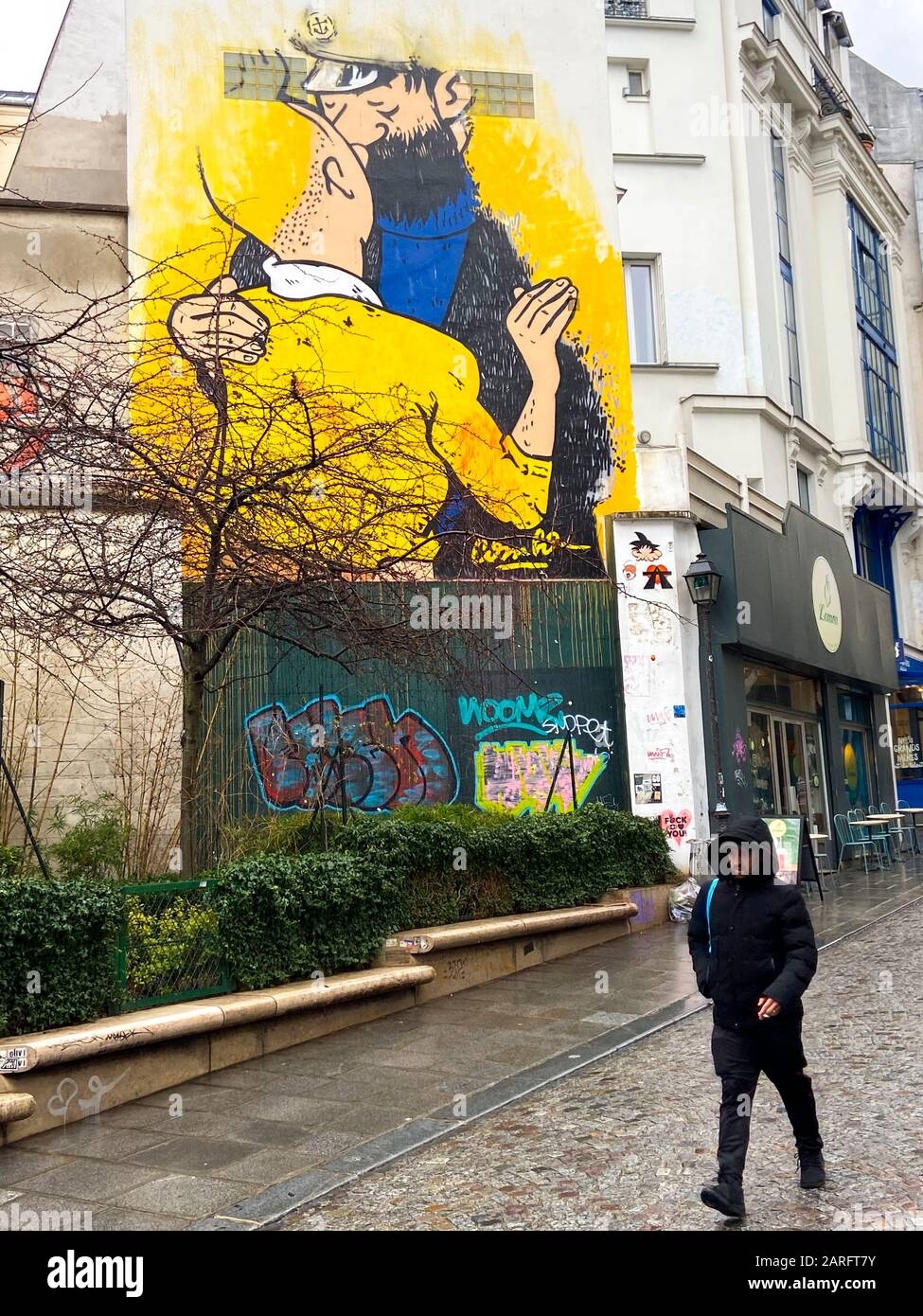 STREET ART :TINTIN AND HADDOCK CAPTAIN KISSING EACH OTHER ON A PARIS WALL Stock Photo