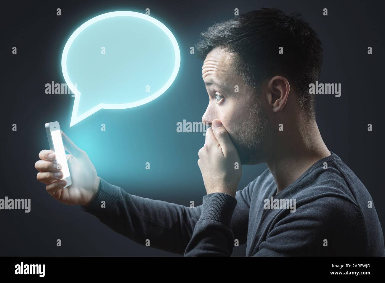 Appalled man getting a message on his smartphone Stock Photo