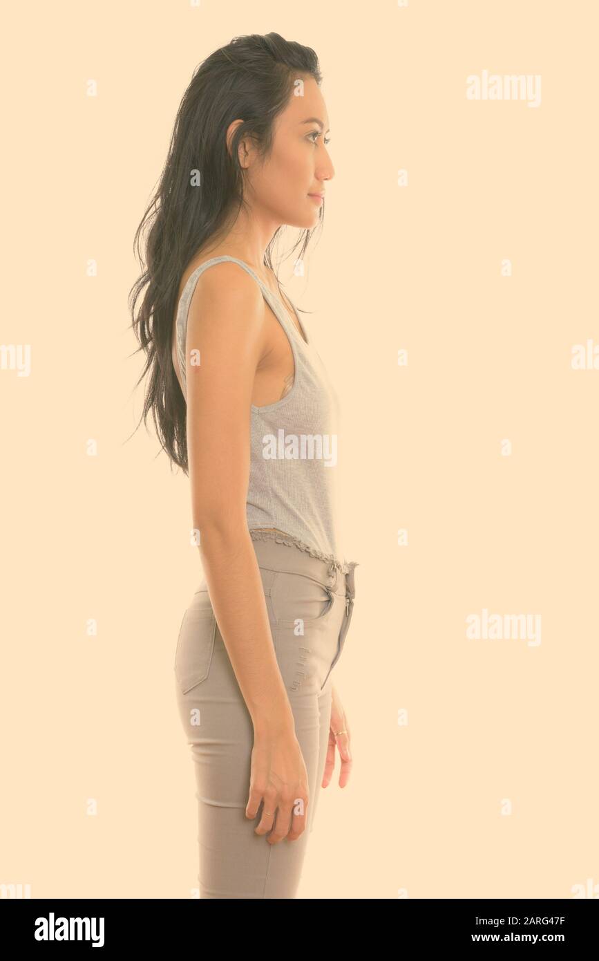 Profile view of young beautiful Asian woman standing Stock Photo - Alamy