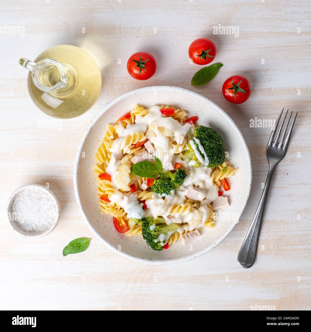 Pasta fusilli with vegetables, boiled steamed meat, white sauce on