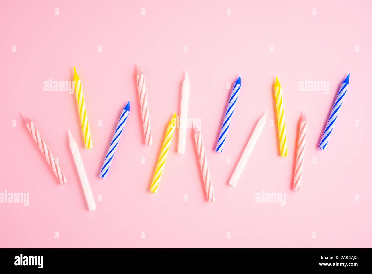 Creative concept food holiday birthday celebration photo of cake candles with hearts and decorations on pink background. Stock Photo