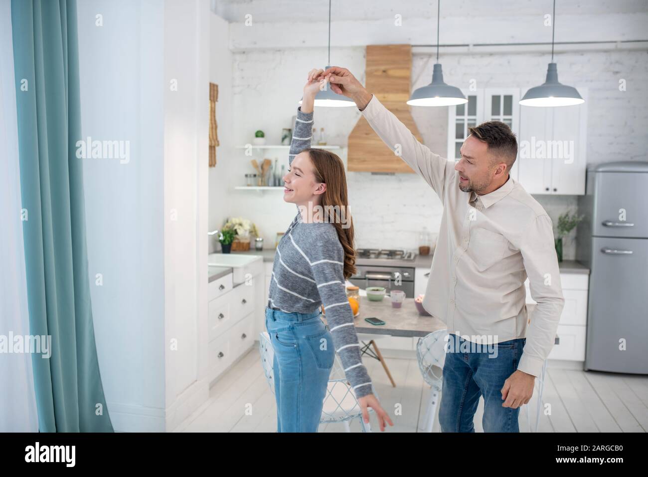 Happy father and daughter dancing at home. Stock Photo
