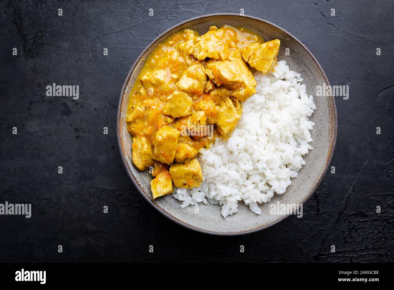 Spicy chicken cooked with curry sauce and rice, top view Stock Photo