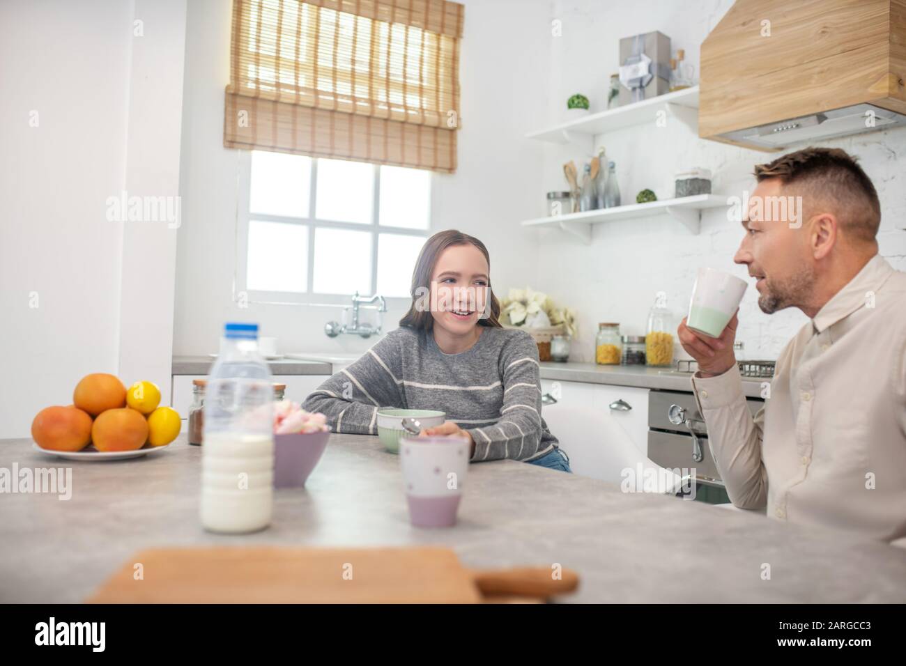 Daughter and father in a good mood at breakfast. Stock Photo